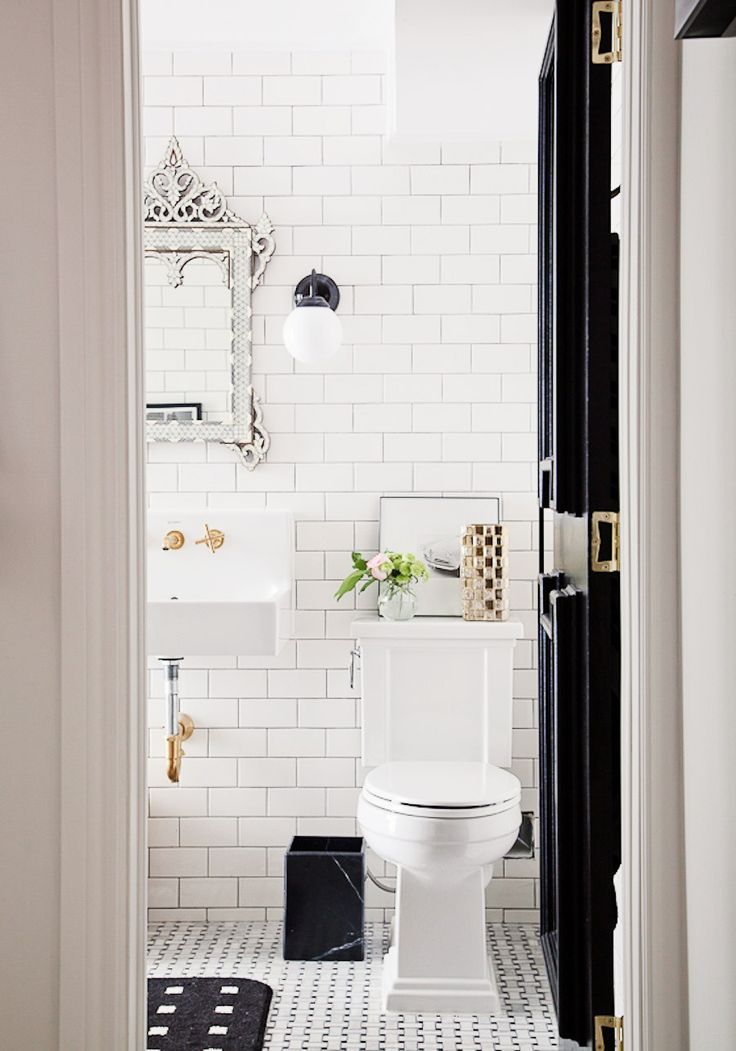 White tiled bathroom with white mirror and black d