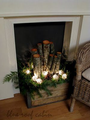 Love the rustic crate with fresh cedar, logs and lights in it.
