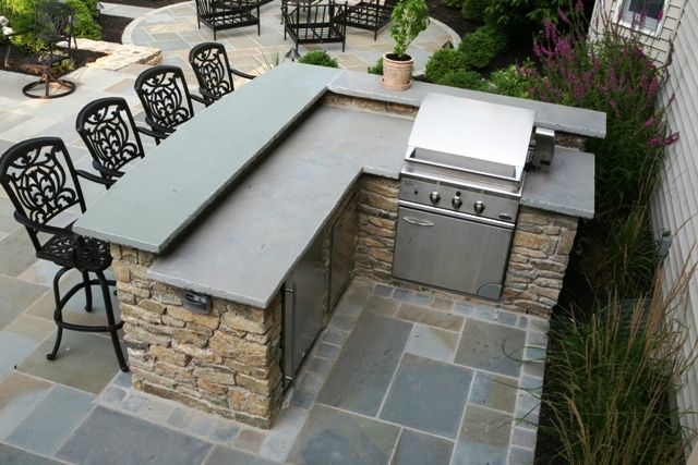 utdoor grill and bar design plans | Outdoor fieldstone kitchen featuring raised stone bar counter, grill ...