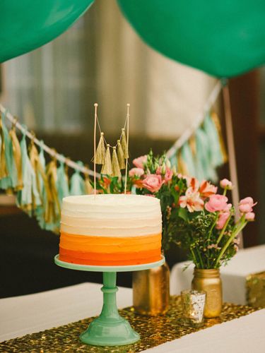An ombre cake—featuring a cute gold tassle cake topper—adds an extra punch of color to the dessert table.