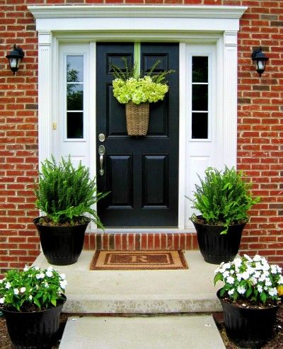 Black door, white trim, red brick house.