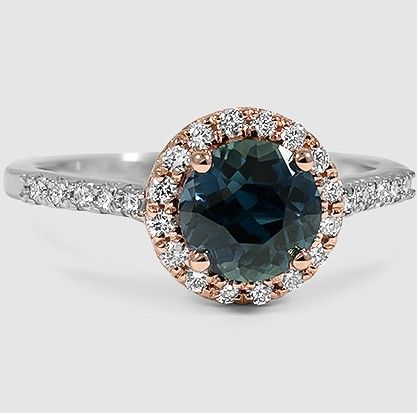 A premium teal round sapphire is surrounded by a halo of brilliant scalloped pavé diamonds in the Serenity Diamond Ring.