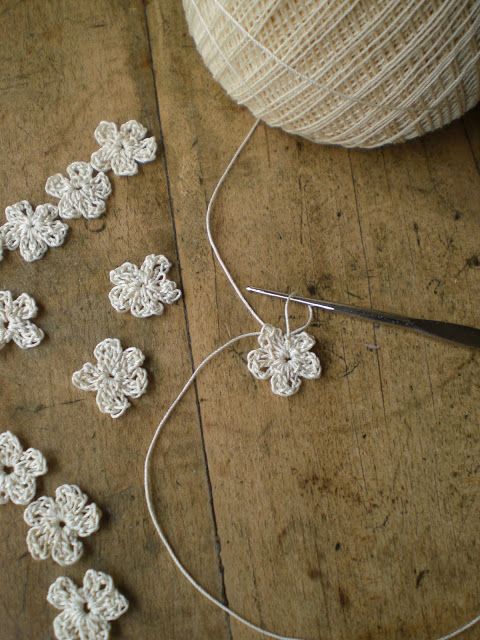 How to make a tiny flower:  form a magic ring ~ into this ring crochet  ... 3 chain stitches, one double crochet, 3 chain stitches, one slip stitch.  Repeat this 4 more times ~ making the 5 petals for the flower ~ finishing with a slip stitch. Now just fa
